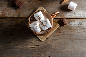 The dessert food vintage style : The Marshmallow with hot chocolate in copper cup on the wooden table. Background copy space for copy text