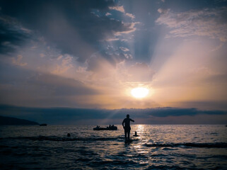 silhouettes of Group of young people swiming during the sunset. Beach holidays travel concept