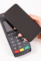 Hand of woman using payment terminal and smartphone to cashless paying. Finance concept
