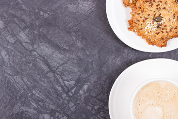 Cup of coffee with milk and fresh baked healthy oatmeal cookies. Delicious crunchy dessert. Place for text or inscription