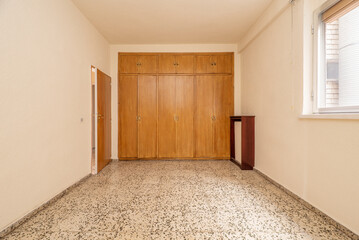 Terrazzo floors in empty bedrooms, fitted wardrobes and trunks completely covering the wall, covers radiators and gotelet white paint