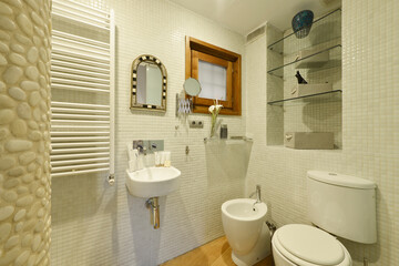 Fototapeta na wymiar Toilet with design toilets in white porcelain, towel-drying radiator and tile on the walls