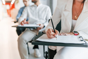 Sitting by the tables and learning new stuff. Group of professional business people is in the office