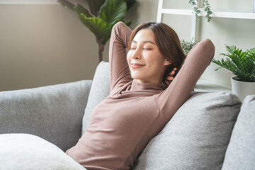 calm young woman relaxing on sofa at home in weekend. - obrazy, fototapety, plakaty