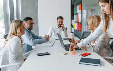 Obraz premium Sitting by the table together and having a conversation. Group of professional business people is in the office