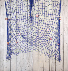 blue fishing net on white wooden wall