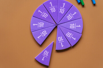 Violet pieces of fractions on a table. Close up math material for study. Back to school, geometry...