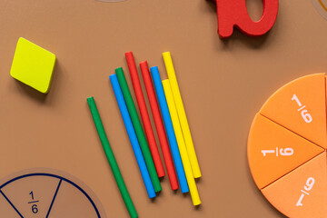 Set of supplies for mathematics and for school. Fractions, rulers, pencils, notepad on brown background,  Back to school, fun education concept