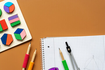 Set of supplies for mathematics and for school. Fractions, rulers, pencils, notepad on brown...