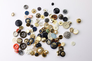 Bottoni di varie forme, colori e dimensioni isolati su fondo bianco