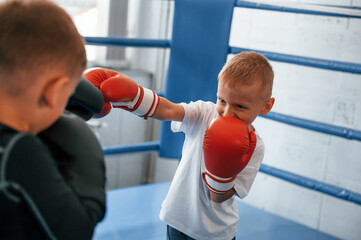 Fighting on the ring. Boys training boxing in the gym together