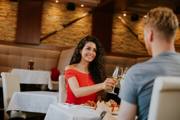 Young couple having lunch with white wine in the restaurant