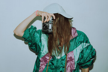 Cool teenager. Fashionable girl in colorful trendy jacket and vintage retro sunglasses with camera...