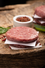 Raw beef meat burger steak cutlets and dry red pepper wooden background