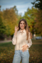 Portrait of a young beautiful girl on an autumn day in the park. There is artistic noise.