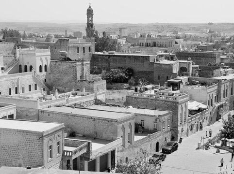 Black and white photo with panoramic view of Midyat city with historical houses, mosque and Assyrian church in Southeast Anatolia region, Turkey
