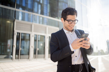 A businessman man uses the phone to work in the office in a business suit