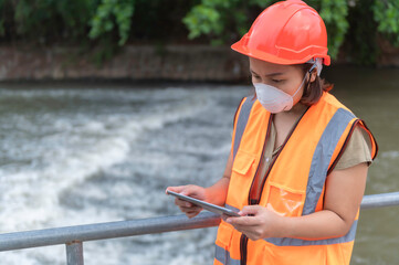 Asian Female engineering working . at sewage treatment plant,Marine biologist analysing water test...