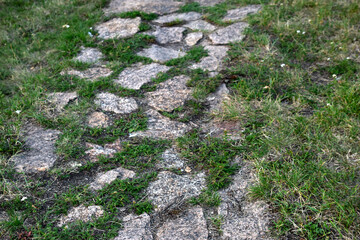 A stone path in the park and a granite staircase with steps. Stone steps in the garden.