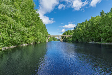 Fototapeta na wymiar Stone railway bridge over the river at summer day.
