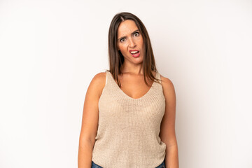 hispanic pretty woman feeling puzzled and confused, with a dumb, stunned expression looking at...