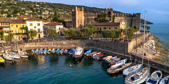 Scenic places of beautiful lake Lago di Garda. aerial view of charming village Torri del Benaco and medieval castle. Italy, Verona province