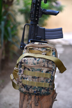 An ammunition bag with an automatic carbine rifle over a piece of wood. A concept image for personal security, home security, gun control, and the US military power.