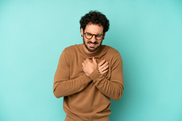 young bearded man looking sad, hurt and heartbroken, holding both hands close to heart, crying and...