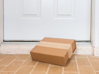 Package box delivered to a residential doorstep. Online order package delivery to the front porch...