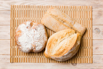 Assortment of freshly baked bread with napkin on rustic table top view. Healthy unleavened bread. French bread
