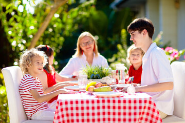 Family eating outdoor. Garden summer fun.