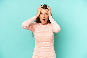 young adult pretty woman feeling horrified and shocked, raising hands to head and panicking at a...