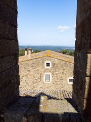 Vistas desde el campanario de la iglesia de Sant Cebri&agrave; de Lled&oacute;  de una mas&iacute;a rural t&iacute;pica de piedra, con chimenea, puertas , ventanas y el bosque al fondo , Girona, en oto&ntilde;o de 2021