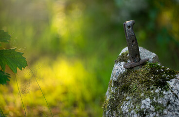 The handle of an antique knife sticks out of a granite stone. Artifacts of the last war. A rusty knife in the stone.