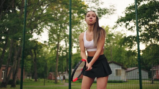 attractive young woman is playing tennis on court, training and competition, slow motion shot