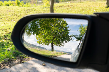 Fototapeta premium Looking in the side rear-view mirror in the day of dreams