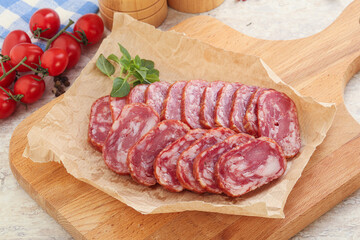 Sliced salami sausages over board