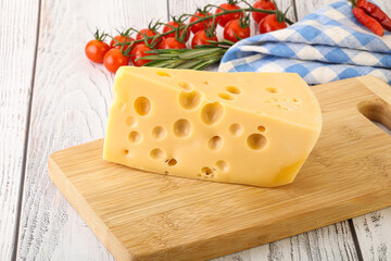 Maasdam cheese piece over board
