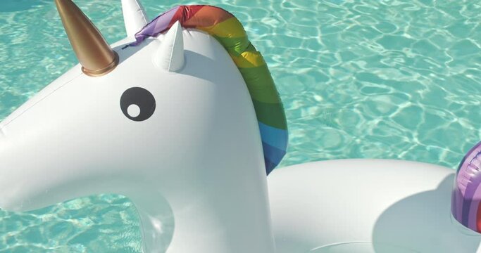 Close-up Inflatable Circle Unicorn Floats in Outdoor Infinity Swimming Pool on Sunny Day Luxury Hotel Resort. Summer Holidays, Travel Vacation. High quality 4k footage