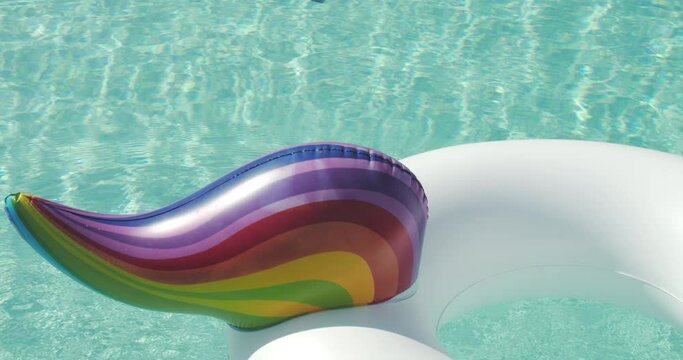 Close-up Inflatable Circle Unicorn Floats in Outdoor Infinity Swimming Pool on Sunny Day Luxury Hotel Resort. Summer Holidays, Travel Vacation. High quality 4k footage