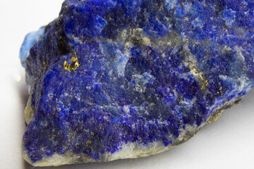 Raw Lapis lazuli rock on white background. Unpolished chunk of lapis lazuli sitting on white...
