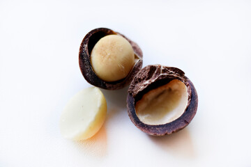 Whole nut and Macadamia kernel on a white background. Delicious whole nuts.