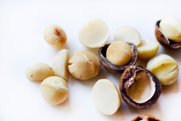 Whole nut and Macadamia kernel on a white background. Delicious whole nuts.