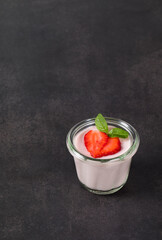 Vegan Strawberry cream pudding, Panna Cotta in a glass. Dark grey background. Copy space