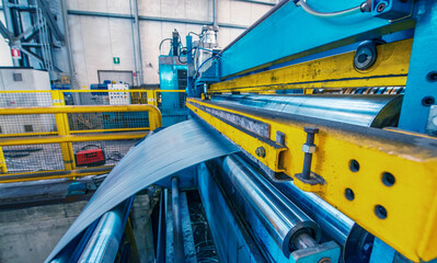 Cutting machine with roll of galvanized steel sheet. Ironworks and metalwork manufacturing factory...