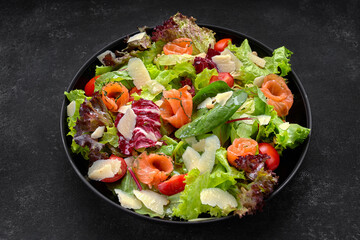 Salad with salmon, parmesan cheese, tomatoes and salad mix
