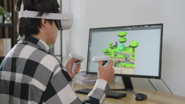 Asian male developer using computer to designer game at home. He using vr to control his 3d design. Technology, Development, Designer, Engineering Concept.