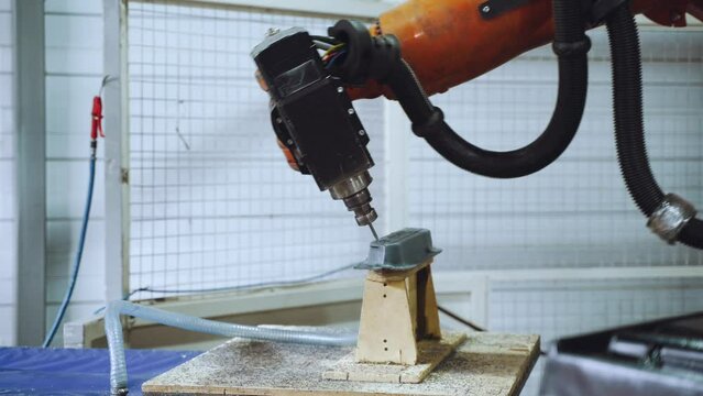 The robot arm cuts out a part, an automated machine at the factory