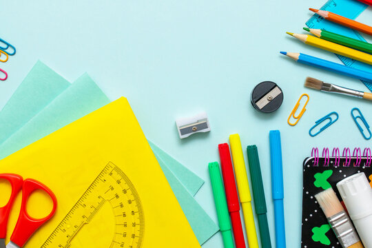 Stationery for studying at school lies on blue. Back to school. Books and textbook, apple material for creativity. View from above.