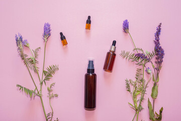 Flat lay composition with lavender flowers and natural cosmetics on a pink background.